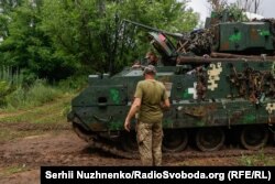 Український військовий біля американської бойової машини піхоти (БМП) M2 Bradley. Україна, червень 2023 року/