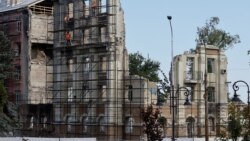 Окупаційні адміністрації конфісковують житло, призначаючи його «нічийним». На фото: робітники відновлюють зруйнований будинок, Маріуполь, серпень 2023 року