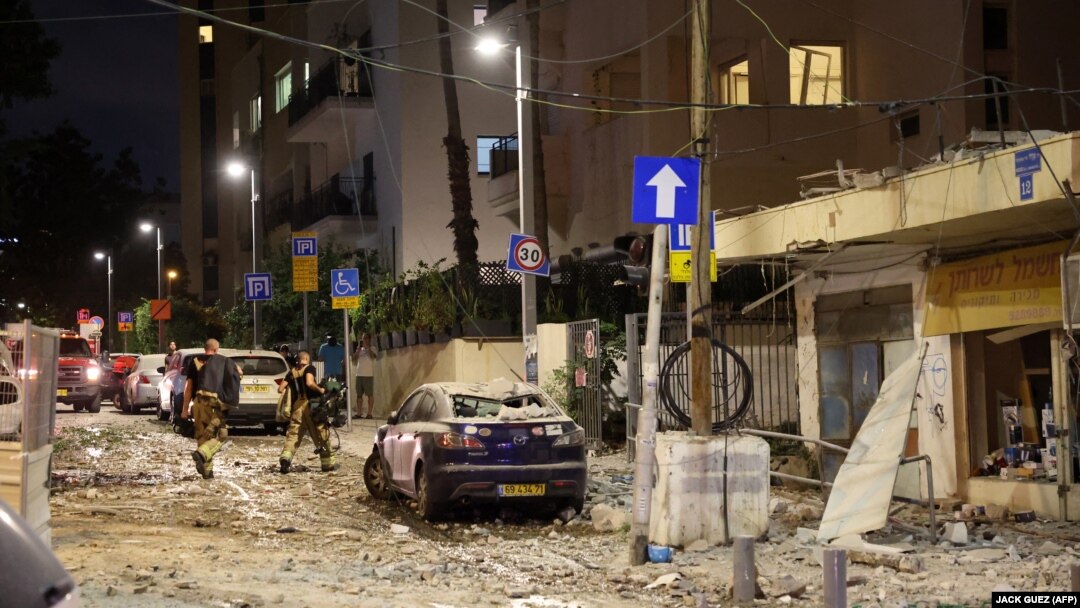 Pripadnici izraelskih snaga sigurnosti hodaju ulicom prepunom krhotina u Tel Avivu, nakon što je pogođena raketom koju su ispalili palestinski militanti iz Pojasa Gaze 7. oktobra 2023.