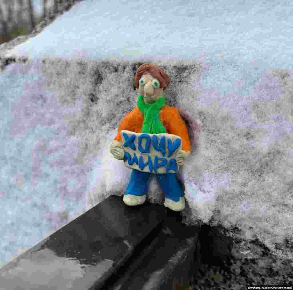 A tiny figure holding a sign saying “I want peace” in St. Petersburg. 