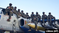 Пілоти ВПС України позують для спільного фото 4 травня 2023 року. Вони сидять на штурмовику Су-25 на одній із баз на сході України