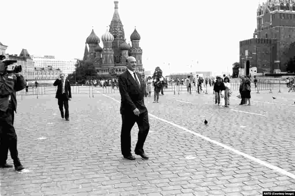Генеральний секретар НАТО Манфред Ворнер крокує Красною площею під час візиту до Москви в липні 1990 року. «Насіння» нового розколу між Москвою і Заходом, очевидно, було посіяне, коли державний секретар США Джеймс Бейкер заявив радянському керівництву в лютому 1990 року, що «якщо Сполучені Штати збережуть свою присутність в Німеччині в рамках НАТО, то жоден дюйм нинішньої військової юрисдикції НАТО не пошириться в східному напрямку». Цю думку повторив, хоча і не погодився з нею офіційно, міністр закордонних справ Німеччини Ганс-Дітріх Геншер