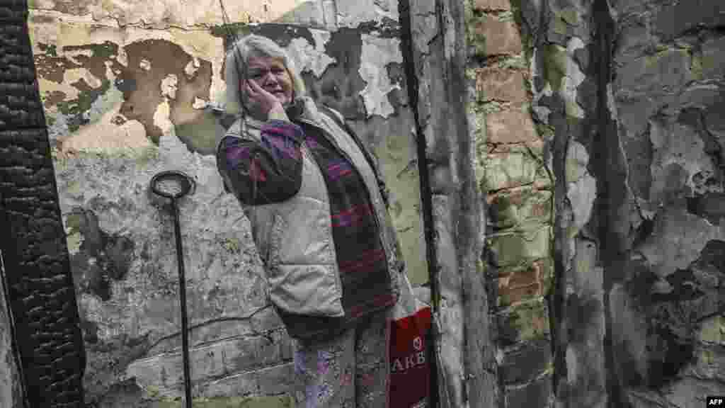 UKRAINE-A woman reacts as she stands inside a burnt house hit by Russian Grad rockets in Kyiv's Shevchenkivsky district, on March 22, 2022, as for the first time, there are signs that Ukrainian forces are going on the offensive, retaking a town near Kyiv