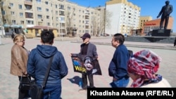 Юрист Ербол Аккужанов на площади имени Ауэзова в городе Семей держит плакат надписью: «No war» («Нет войне»). Семей, 15 апреля 2022 года