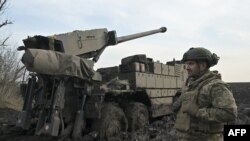 Український військовослужбовець Десантно-штурмових військ стоїть поруч із колісною самохідною гаубицею CAESAR 8x8 на передовій, південь України, 14 лютого 2024 року 
