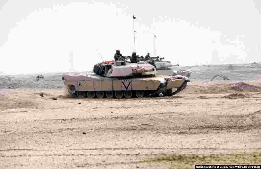 Два основні бойові танки Корпусу морської піхоти США M-1A1 Abrams рухаються пустелею під час наземної фази операції «Буря в пустелі» 24 лютого 1991 року. Хоча M1 Abrams надійшли на озброєння в 1980 році, вперше участь в бою танки взяли під час операції «Буря в пустелі»