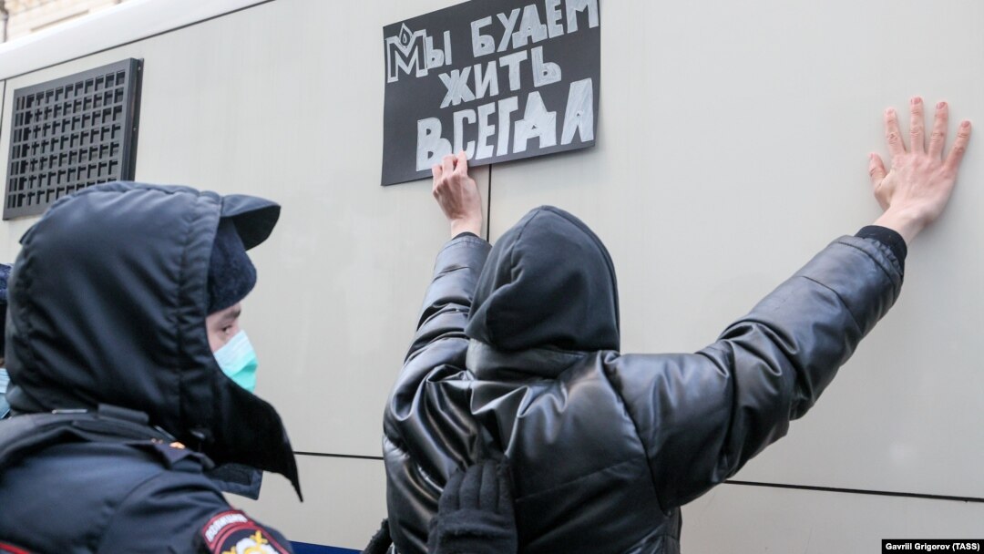 Полицай задържа поддръжник на правозащитната неправителствена организация "Мемориал" по време на протест срещу обявяването ѝ за "чуждестранен агент" от Русия. Протестиращият държи надпис на руски език с логото на "Мемориал": "Винаги ще сме живи", Москва, 28 декември 2021 г.