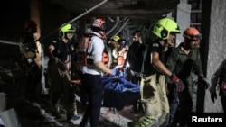 Spasilačke ekipe nose ranjenu osobu nakon iranskog raketnog udara na Izrael, u Ramat Ganu, 13. juna