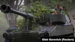 Українські військовослужбовці їдуть на американській 155-мм самохідній баштовій гаубиці М109. Донеччина, 13 червня 2022 року