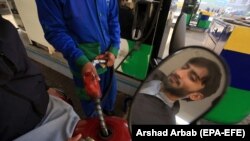 په پېښور کې یو کس په خپل موټرسایکل کې تېل اچوي - پخوانی انځور. 