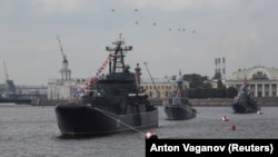 Руски военни хеликоптери летят над военноморски кораби на Балтийския флот в река Нева по време на репетиция за парада за Деня на военноморските сили в Санкт Петербург, Русия. Архивна снимка от 28 юли 2017 г.