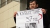 Almaty şäheriniň ýerli sudunyň oňünde oppozision aktiwistleriň tussag edilmegine protest bildirilip gurnalan pikete gatnaşyjylardan biri şygar göterip dur. Almaty, 26-njy ýanwar 2012. 