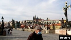 Чоловік у захисній масці на Карловому мосту в Празі
