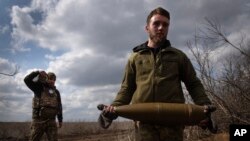 Українські військові несуть снаряди, щоб відповісти росіянам на лінії фронту поблизу міста Бахмут. Донеччина, 25 березня 2024