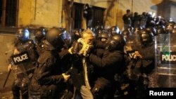 Маскирани полицаи арестуват демонстрант в Тбилиси на 29 ноември 2024 г.