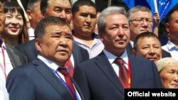 «Эмгек» партиясынын нрегиздөөчүсү, ишкер Аскар Салымбеков (солдо) жана «Бүтүн Кыргызстан» партиясынын лидери Адахан Мадумаров (оң тарапта). 2015-жылдагы парламенттик шайлоо.