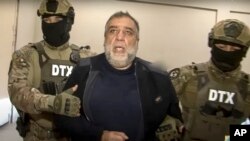 In this photo taken from video released by Azerbaijan's State Security Service on September 28, 2023, Ruben Vardanyan is escorted by Azerbaijani security agents in Baku.