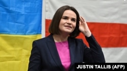 Світлана Тихановська на тлі прапору України та національного стягу Білорусі під час виступу в Лондоні перед білоруською діаспорою