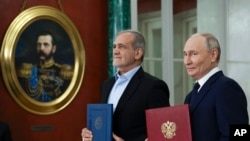 Russian President Vladimir Putin (right) and Iranian President Masud Pezeshkian attend a signing ceremony earlier this year for a partnership treaty after talks at the Kremlin in Moscow.