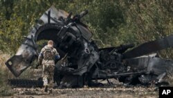 Український військовий біля знищеного російського танка поблизу звільненої Балаклеї на Харківщині, 11 вересня 2022 року
