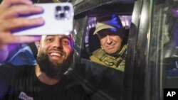 Ростов-на-Дону шаарынын тургуну аскердик автоунаада бараткан "Вагнердин" жетекчиси Евгений Пригожин менен сүрөткө түшүп жаткан учур. 24-июнь, 2023-жыл.