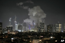 O coloană uriașă de fum se înalță deasupra Tel-Avivului, după un atac iranian cu rachete, 13 iunie 2025.